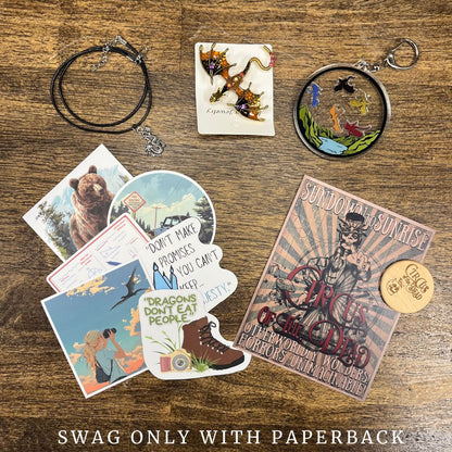 Collection of swag items including a necklace, keychain, and various cards on a wooden surface.